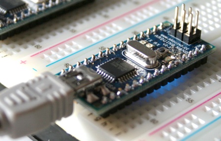 Arduino Nano 2.2, подсоединенная к компьютеру при помощи кабеля с разъемом Mini-B. Обратите внимание на синий светодиод под платой – это индикатор питания
